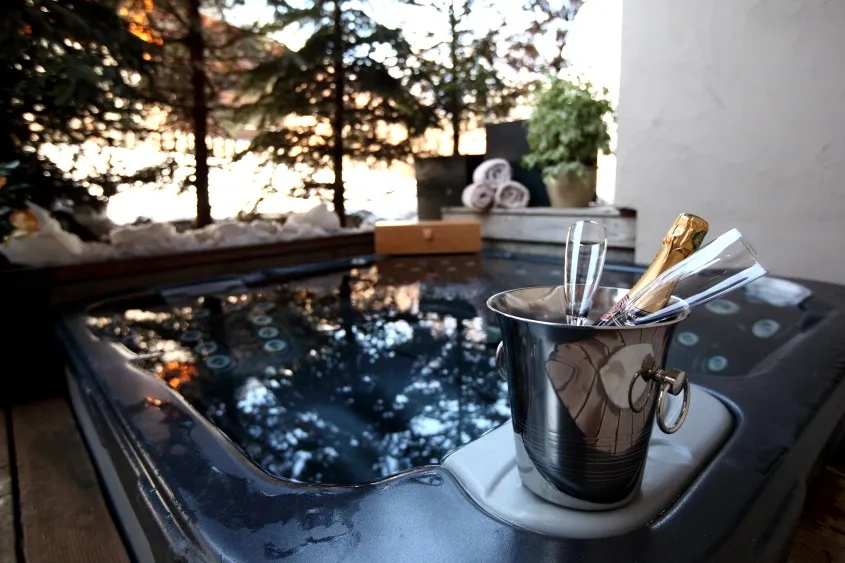 Outdoor hot tub on a snowy alpine terrace